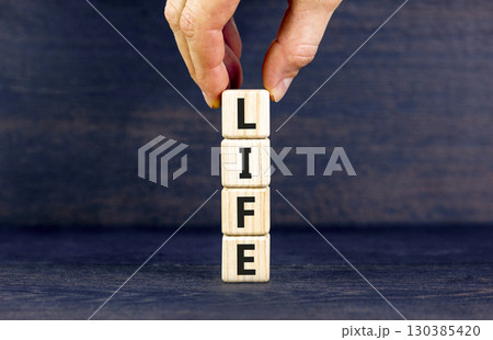 Life symbol. Concept word Life on beautiful wooden blocks. Businessman hand. Beautiful black table black background. Business, lifestyle, support and life concept. Copy space. Life symbol. Concept word Life on beautiful wooden blocks. Businessman hand. Beautiful black table black background. Business, lifestyle, support and life concept. Copy space. 130385420