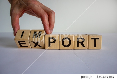 Hand is turning a cubes and changes the word 'import' to 'export'. Beautiful white background. Business concept. Copy space. 130385463
