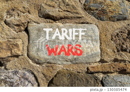 Trade tariff wars symbol. Concept word Tariff wars on beautiful grey stone on stone wall. Beautiful stone wall background. Business trade tariff wars concept. Copy space. 130385474