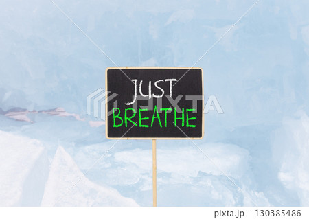 Just breathe and psychological symbol. Concept words Just breathe on beautiful yellow black blackboard. Beautiful blue ice background. Business psychological and Just breathe concept. Copy space Just breathe and psychological symbol. Concept words Just breathe on beautiful yellow black blackboard. Beautiful blue ice background. Business psychological and Just breathe concept. Copy space 130385486