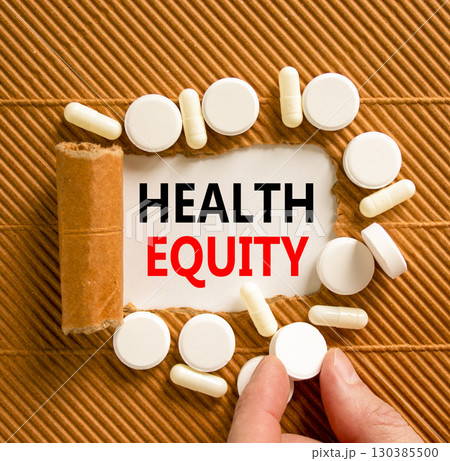 Health equity symbol. Concept words Health equity on beautiful white paper. White pills tablets. Doctor's hand. Beautiful brown background. Medical healthy lifestyle health equity concept. 130385500