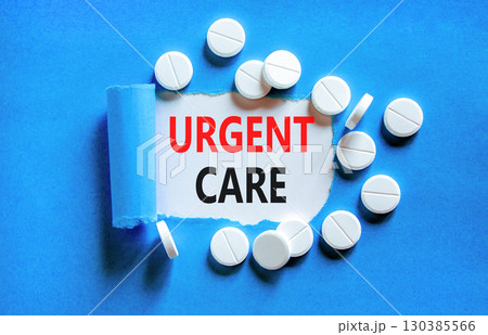Urgent care symbol. Concept words Urgent care on beautiful white paper. White pills tablets. Beautiful blue background. Medical healthy lifestyle urgent care concept. 130385566