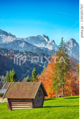 Fabulous view of alpine meadow with wooden huts  near Wagenbruchsee (Geroldsee) lake 130385707