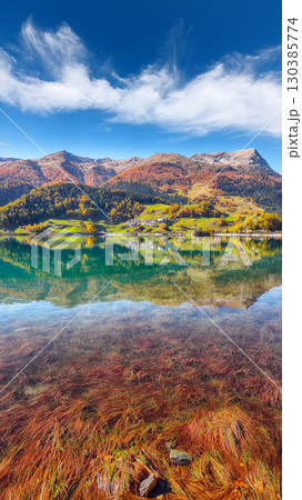 Picturesque autumn view of San Valentino village and Muta or Haidersee lake. 130385774