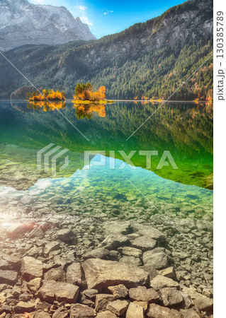 Stunning autumn landscape of Eibsee Lake in front of Zugspitze summit under sunlight. 130385789