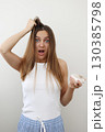 Shocked young woman with hair loss problem holds on to the hair and hairbrush with bunch of fallen hair after combing. Postpartum period, menstrual or endocrine disorder, hormonal imbalance, stress 130385798