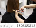 Unrecognisable hairdresser cutting female client hair with professional barber scissors and comb and making stylish haircut short bob hairstyle in beauty salon. Hair care, hair salon and hairstyling 130385812
