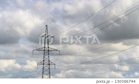 Starlings are seen flying and circling near power lines set against a cloudy sky backdrop Starlings are seen flying and circling near power lines set against a cloudy sky backdrop 130386744