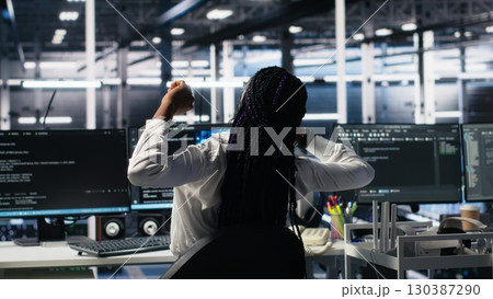 Data center manager checking work done by admins using deep learning to analyze datasets. Server hub supervisor overseeing IT specialists using AI neural networks to recognize data patterns, camera A 130387290