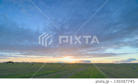 A Beautiful Sunset Spreading Its Colors Over Open Fields with Dramatic Clouds Forming 130387745