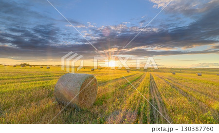 A Magnificent Beautiful Sunset Over a Peaceful Field with Golden Hay Bales Using Natures Colors A Magnificent Beautiful Sunset Over a Peaceful Field with Golden Hay Bales Using Natures Colors 130387760