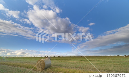 A picturesque scenic countryside showcasing golden bales set under a brilliant blue sky 130387971