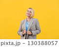 Smiling young blond businesswoman holding blazer 130388057