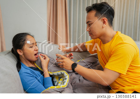 A Caring Partner Who is Assisting Their Sick Loved One with Medication at Home A Caring Partner Who is Assisting Their Sick Loved One with Medication at Home 130388141