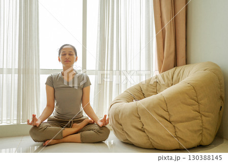 Practicing Mindful Meditation in a Bright and Airy Living Space Full of Light 130388145