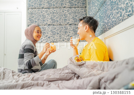 A Loving Couple Enjoying Breakfast Together in a Cozy and Inviting Bedroom Setting A Loving Couple Enjoying Breakfast Together in a Cozy and Inviting Bedroom Setting 130388155