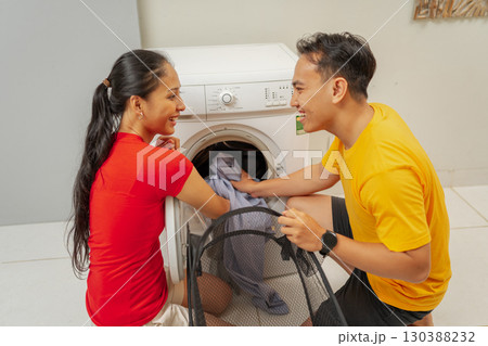 A Couple Joyfully Engaging in Fun Activities While Completing Laundry at Home Together A Couple Joyfully Engaging in Fun Activities While Completing Laundry at Home Together 130388232