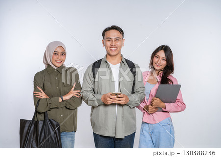 A Diverse Group of Students Smiling Joyfully with Their Gadgets in a Studio Setting A Diverse Group of Students Smiling Joyfully with Their Gadgets in a Studio Setting 130388236