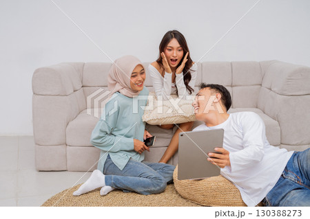 Group of Friends Enjoying Time Together with a Tablet in a Cozy Living Room 130388273