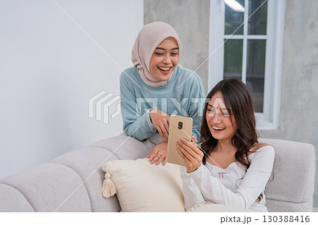 Joyful Friends Happy to Share a Special Moment Together on a Smartphone Device 130388416