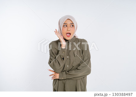 A young woman wearing a hijab looks genuinely surprised and expresses her astonishment A young woman wearing a hijab looks genuinely surprised and expresses her astonishment 130388497