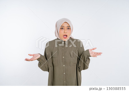 A Surprised Woman Wearing a Hijab is Expressing Confusion with Her Hands Raised A Surprised Woman Wearing a Hijab is Expressing Confusion with Her Hands Raised 130388555
