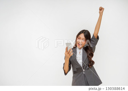 An Excited Businesswoman is Celebrating Her Success While Holding a Smartphone An Excited Businesswoman is Celebrating Her Success While Holding a Smartphone 130388614