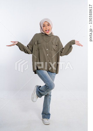 Cheerful Young Woman in Casual Hijab Outfit Posing Against White Background 130388617