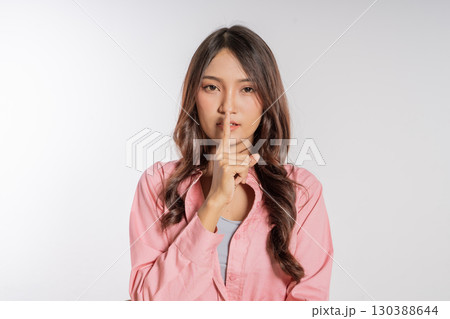 An Elegant Young Woman Making A Shh Gesture in a Creative Studio Setting An Elegant Young Woman Making A Shh Gesture in a Creative Studio Setting 130388644