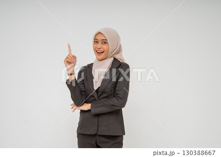 A Confident Businesswoman Dressed in a Stylish Suit with Hijab Pointing Upwards 130388667