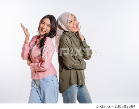 Two friends are posing playfully together in their stylish and casual attire 130388694