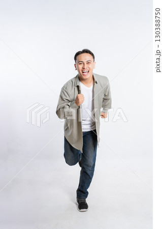 A Vibrant and Energetic Young Man Joyfully Running in a Modern Urban Setting 130388750