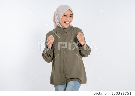 Joyful Young Woman in Casual Outfit with Hijab against White Background 130388751