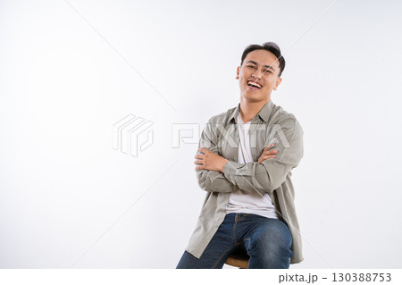 A Happy Young Man Sitting on a Stool Studio Portrait Full of Life and Joy A Happy Young Man Sitting on a Stool Studio Portrait Full of Life and Joy 130388753