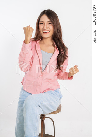 A Joyful Young Woman Celebrating Her Success with an Extremely Cheerful Expression 130388797