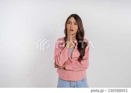 A Thoughtful Young Woman Dressed in a Pink Top Against a Neutral Background A Thoughtful Young Woman Dressed in a Pink Top Against a Neutral Background 130388851