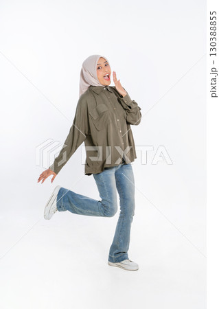 A Joyful and Young Woman Dressed in Casual Attire Posing with a Playful Expression A Joyful and Young Woman Dressed in Casual Attire Posing with a Playful Expression 130388855