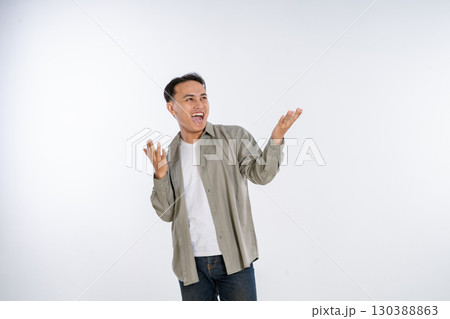 A Joyful Man Expressing Sudden Surprise and Overwhelming Happiness in a Studio Setting 130388863