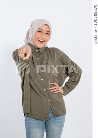A Cheerful Young Woman in a Casual Outfit Pointing Enthusiastically at the Camera 130388870
