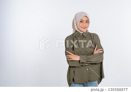 A Confident Young Woman Wearing Casual Attire and Smiling Cheerfully for the Camera 130388877