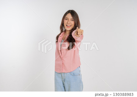A Joyful Young Woman Pointing at the Camera While Dressed in a Casual Outfit 130388983