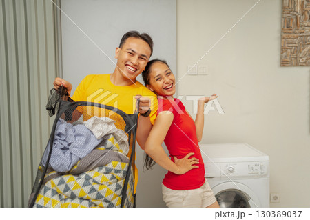 A Joyful and Happy Couple Celebrating Laundry Day at Home with Their Childs Stroller 130389037