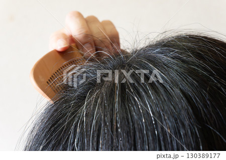 頭頂部に現れた白髪とアホ毛のクローズアップ画像 中高年女性 頭頂部に現れた白髪とアホ毛のクローズアップ画像 中高年女性 130389177