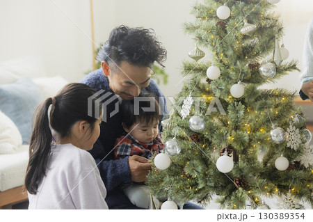 クリスマスツリーを飾る家族 130389354