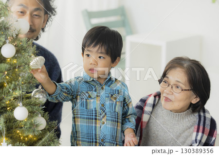 クリスマスツリーを飾る家族 130389356