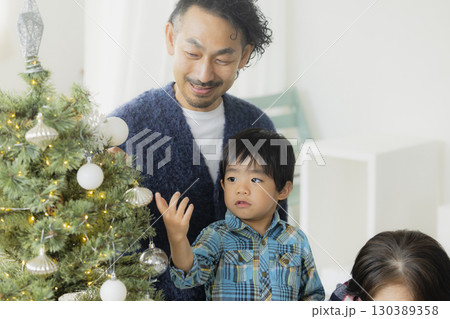 クリスマスツリーを飾る家族 130389358