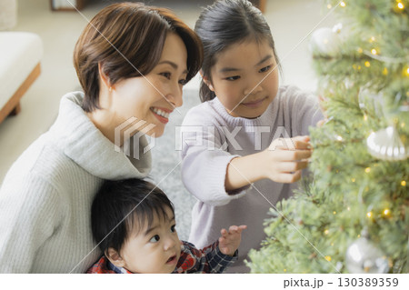 クリスマスツリーを飾る家族 130389359