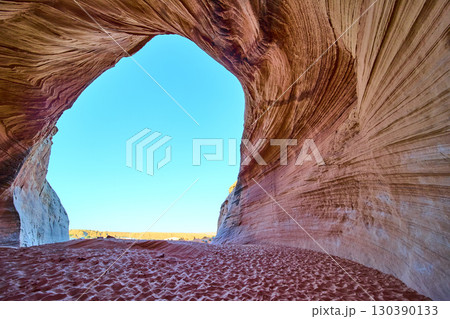 Sandstone Cave Arch with Striated Rock and Blue Sky Upward Motion Perspective 130390133