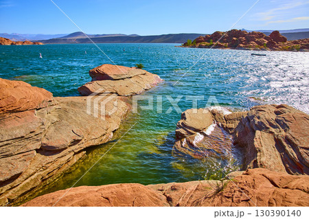 Red Sandstone and Blue Lake Water with Distant Hills Low Angle Lake Edge Red Sandstone and Blue Lake Water with Distant Hills Low Angle Lake Edge 130390140