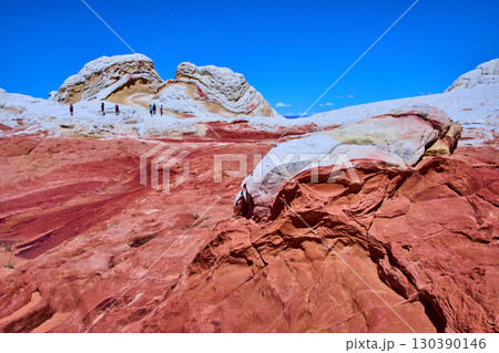 Vermilion Cliffs sandstone formations with hikers under blue sky Marble Canyon 130390146